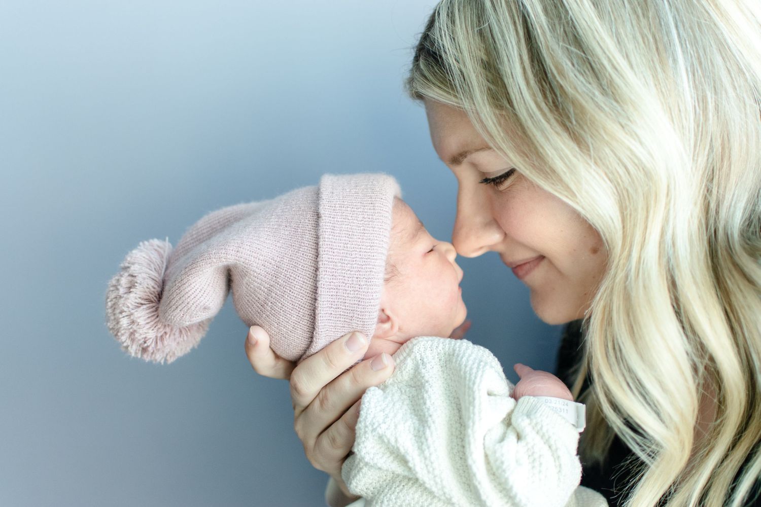 Mom soaks in baby's tiny features during a lifestyle fresh 48 session.