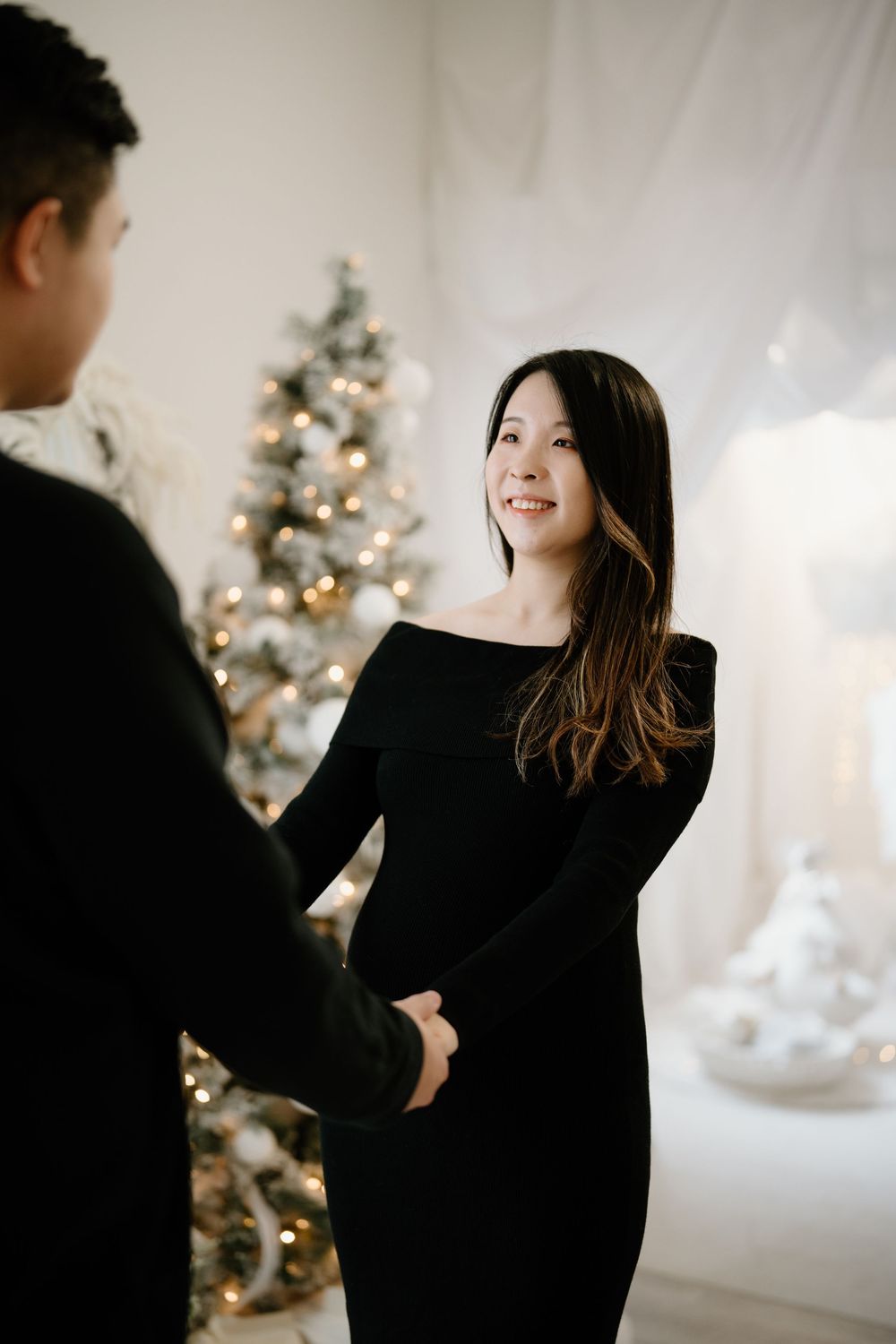 A series of artistic photos showing a person in a black sweater against a light background with a Christmas tree.