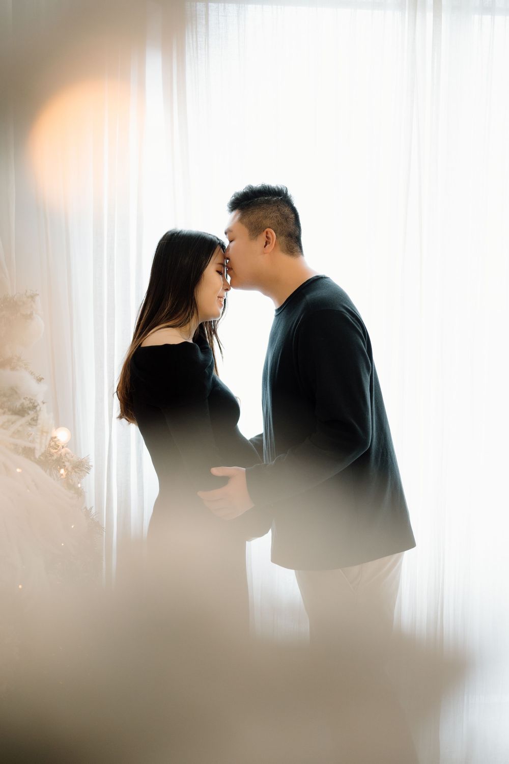 A dreamy, silhouetted couple shares intimate moments in front of white curtain-filtered light in a romantic photo sequence.
