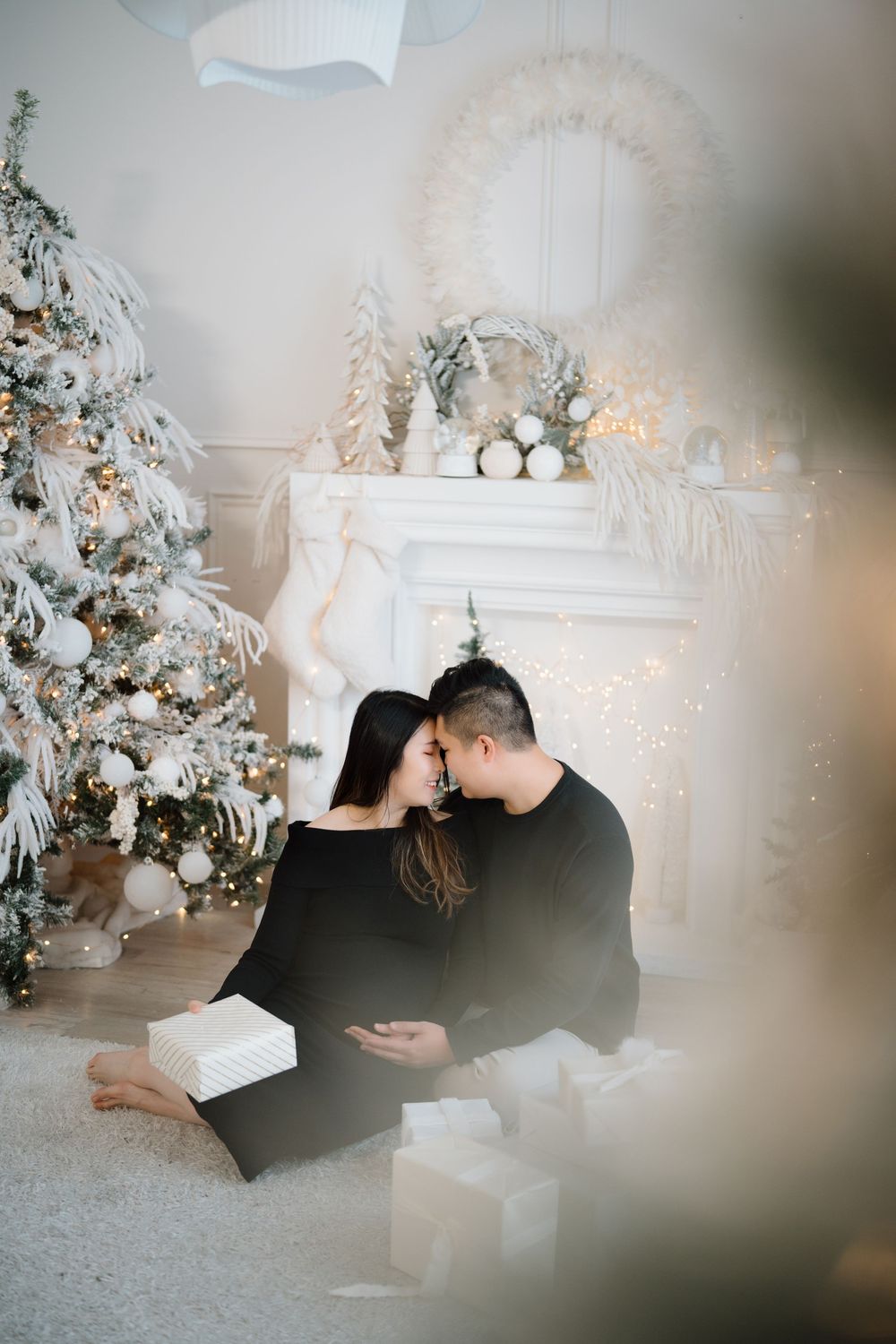 Four black and white romantic moments captured in a dreamy festive winter setting with decorated Christmas trees.