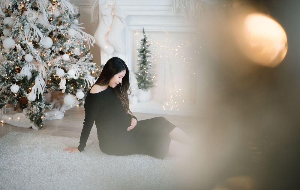 Wedding couple poses near elegant white floral arrangements and twinkle lights creating a romantic winter ambiance.