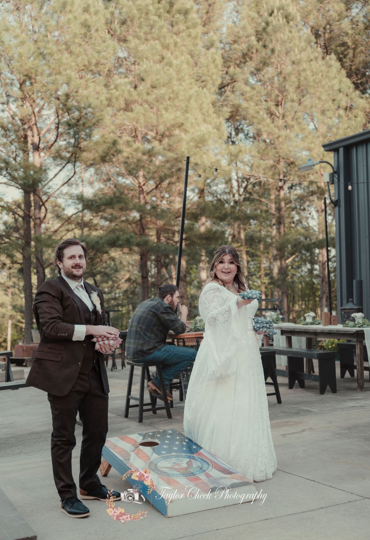 Bride and groom playing cornhole at reception on patio at Sanctuaire Atelier.