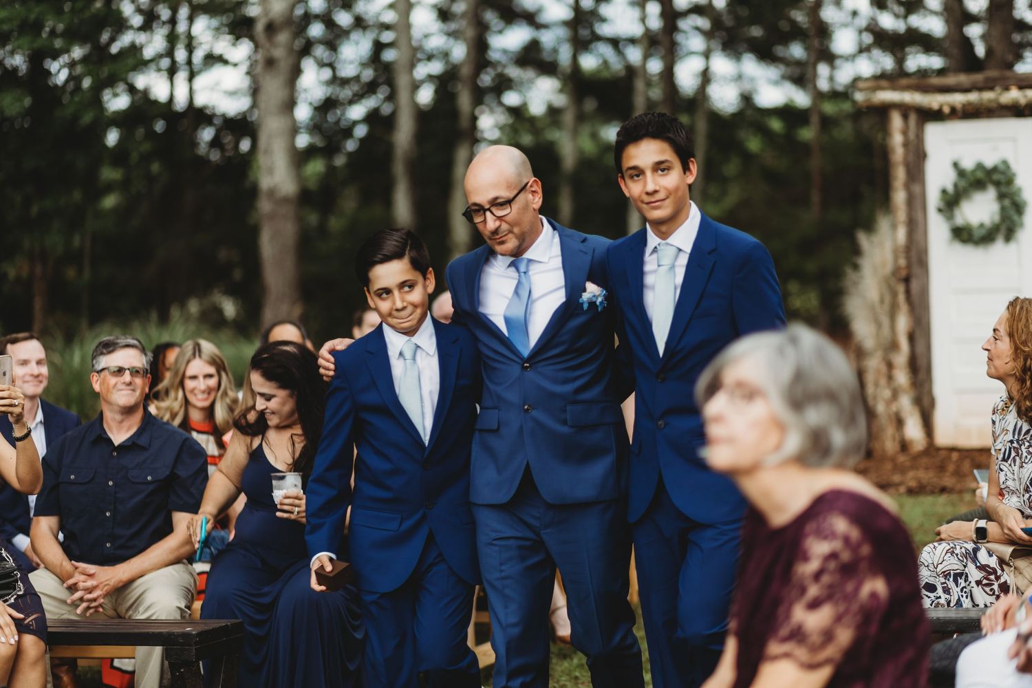 Dad and sons walking down isle for ceremony at Sanctuaire Atelier.