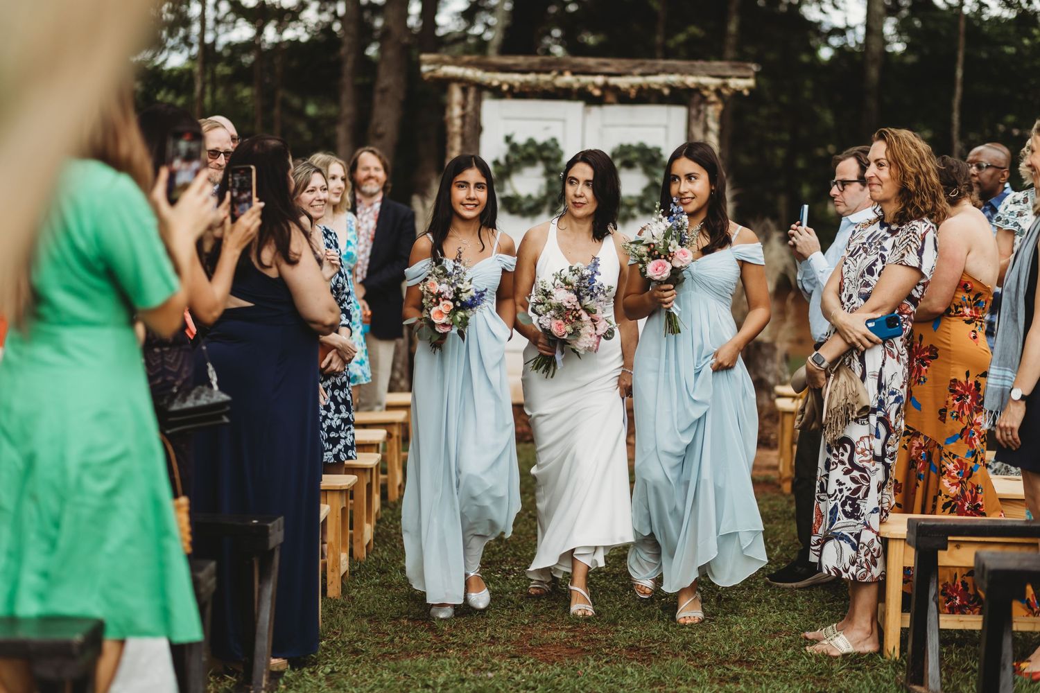 Mom and daughters walking down isle at wedding - Sanctuaire Atelier.