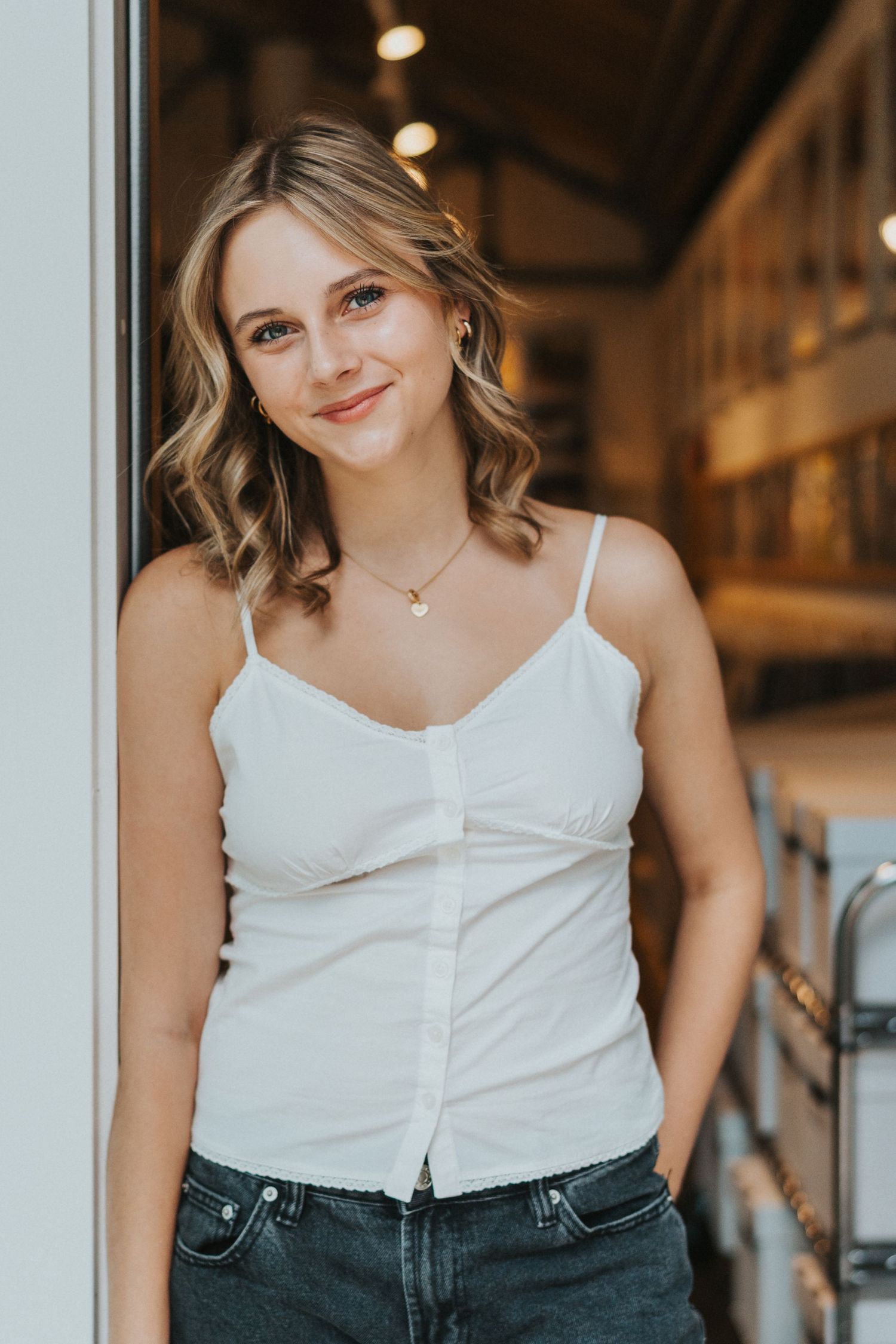 Senior girl leans against doorway of record store
