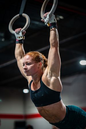 Athlete demonstrating strength on gymnastic rings during workout.
