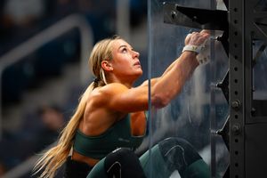 CrossFit athlete looking upward with determination during a competition workout.