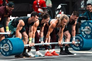 Athletes performing synchronized burpees during an intense CrossFit workout.
