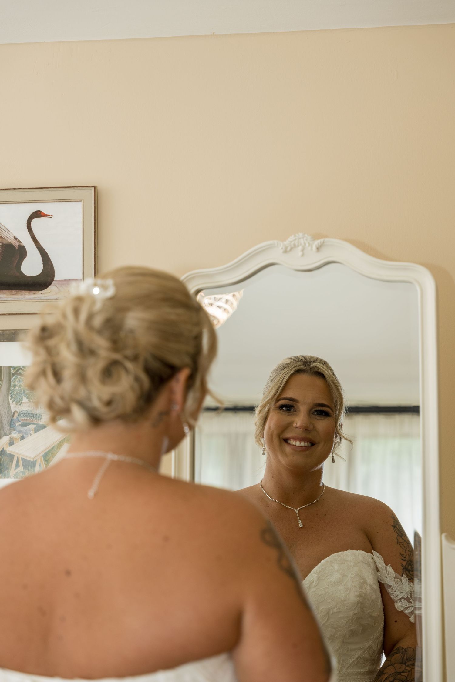 A reflection captured in an ornate mirror shows a bride getting ready for her wedding day.