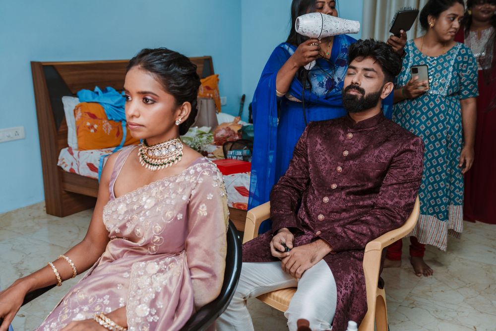 Wedding preparation scene with people in traditional Indian formal attire.