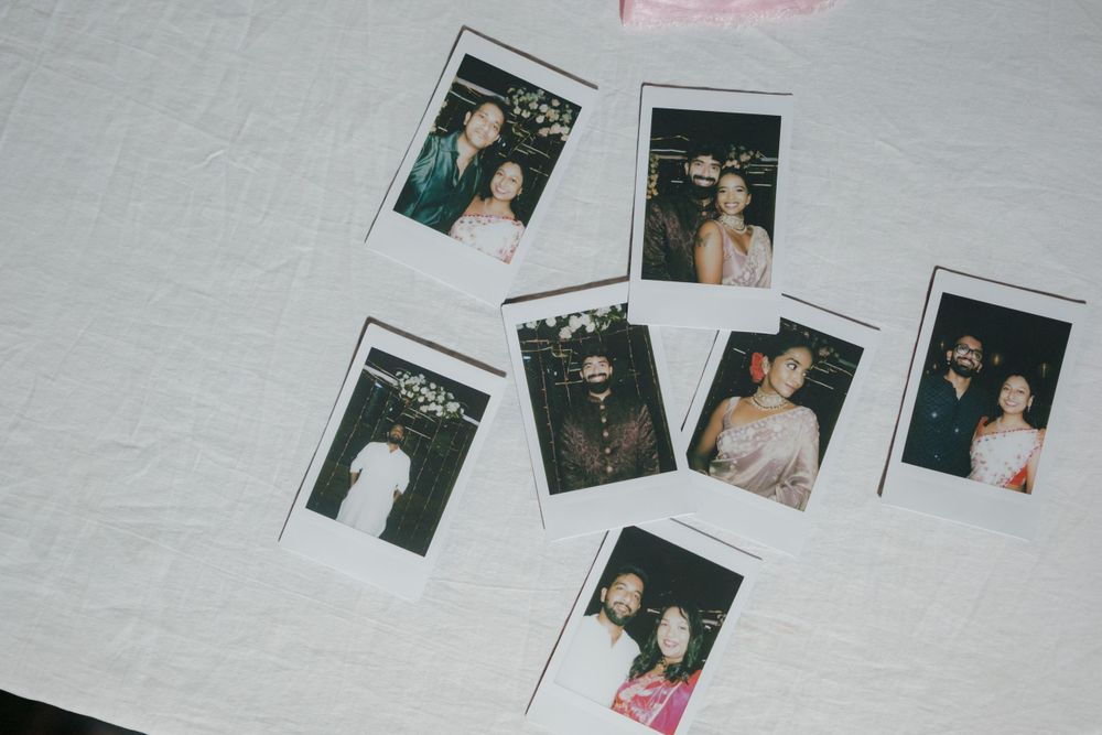Collection of vintage polaroid photos arranged on white textile background.