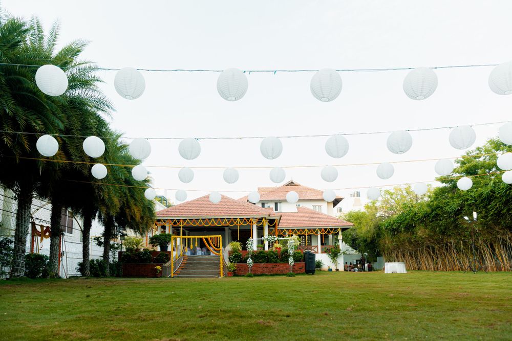 Outdoor venue decorated with white lanterns and string lights for an event.