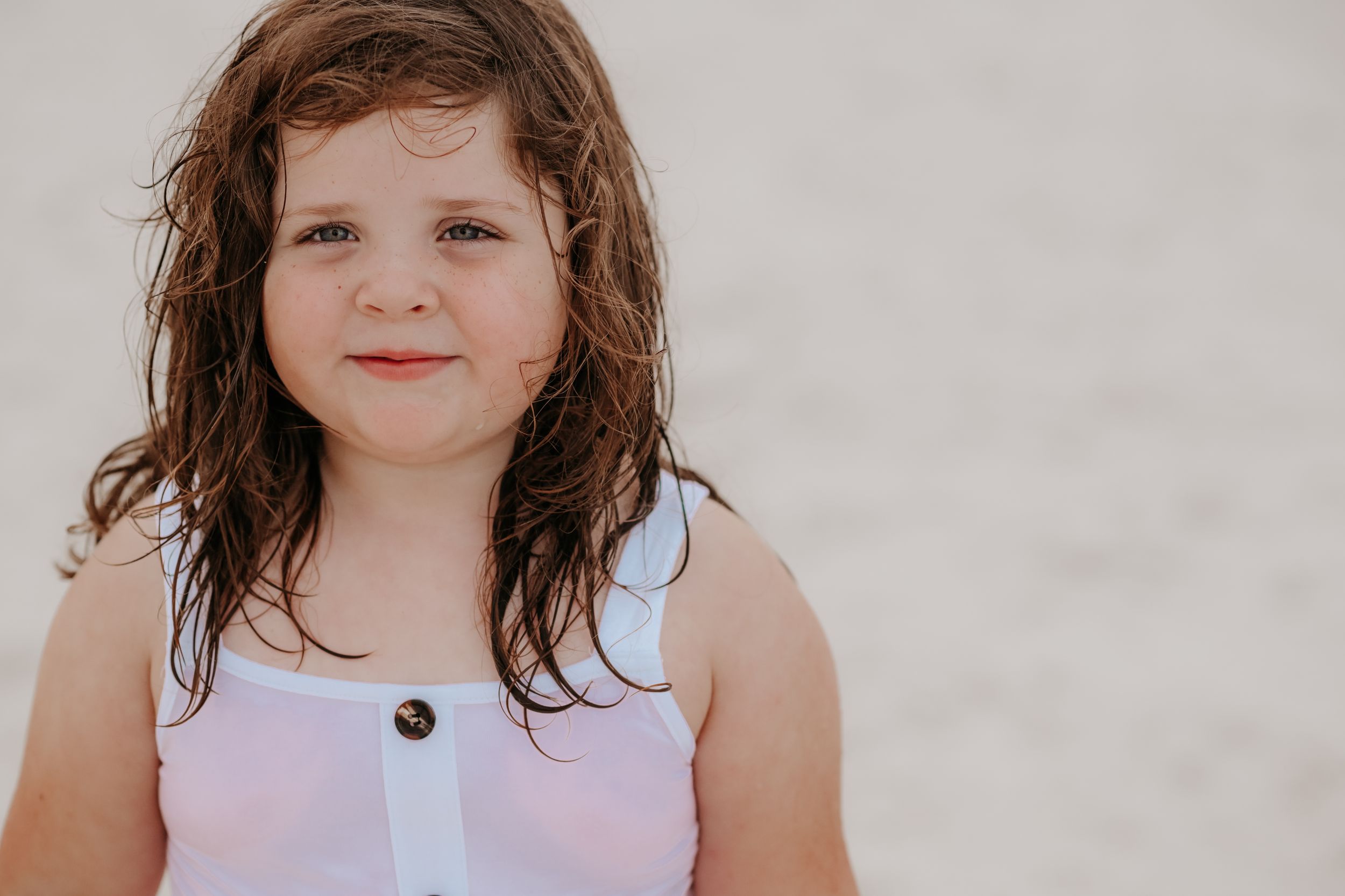 Close-up portrait of a young child with wavy brown hair.