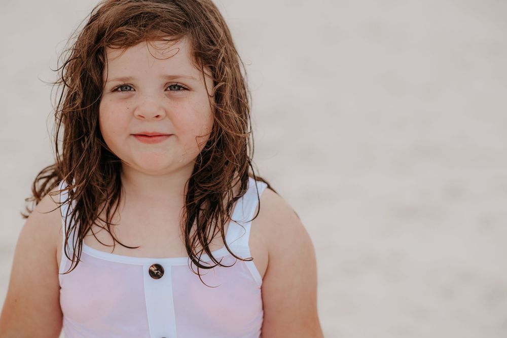 Close-up portrait of a young child with wavy brown hair.