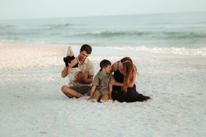 Group lounging on pristine white sand beach at dusk.
