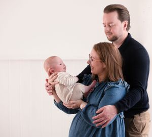family portrait of mum, dad and new born baby.