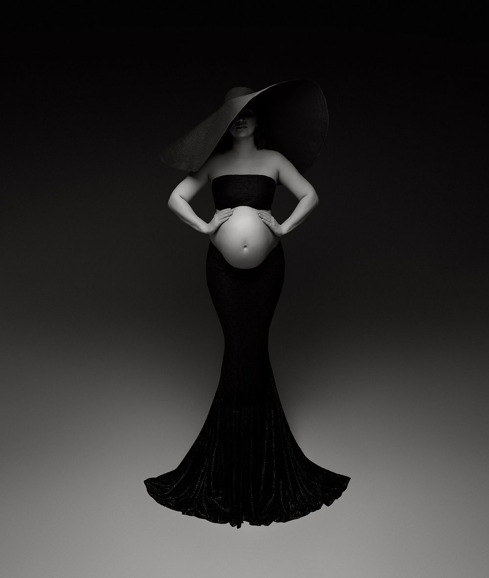 Artistic black and white maternity photoshoot with large black hat and long black skirt in Atlanta photography studio Fine Art House.