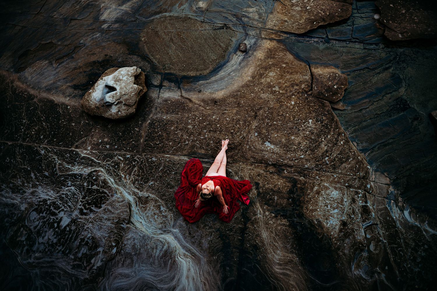 Moody landscape photography of rocky terrain with red accents.