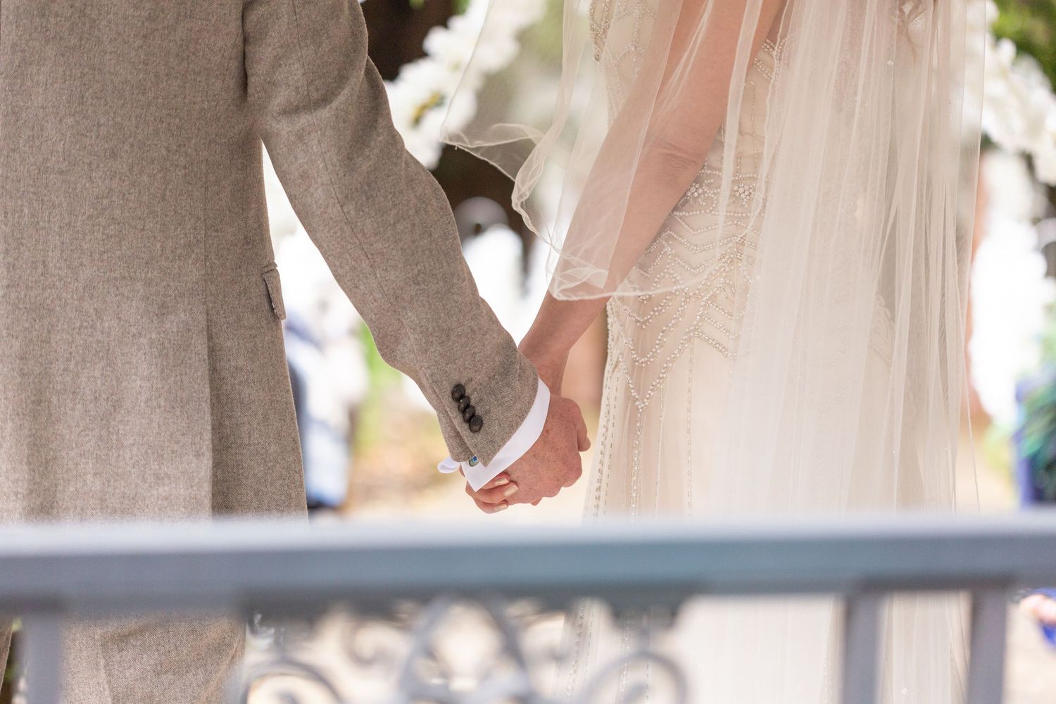 Close-up of couple holding hands during their wedding ceremony.