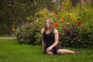 Outdoor portrait series in garden setting with colorful flowers and natural landscaping.