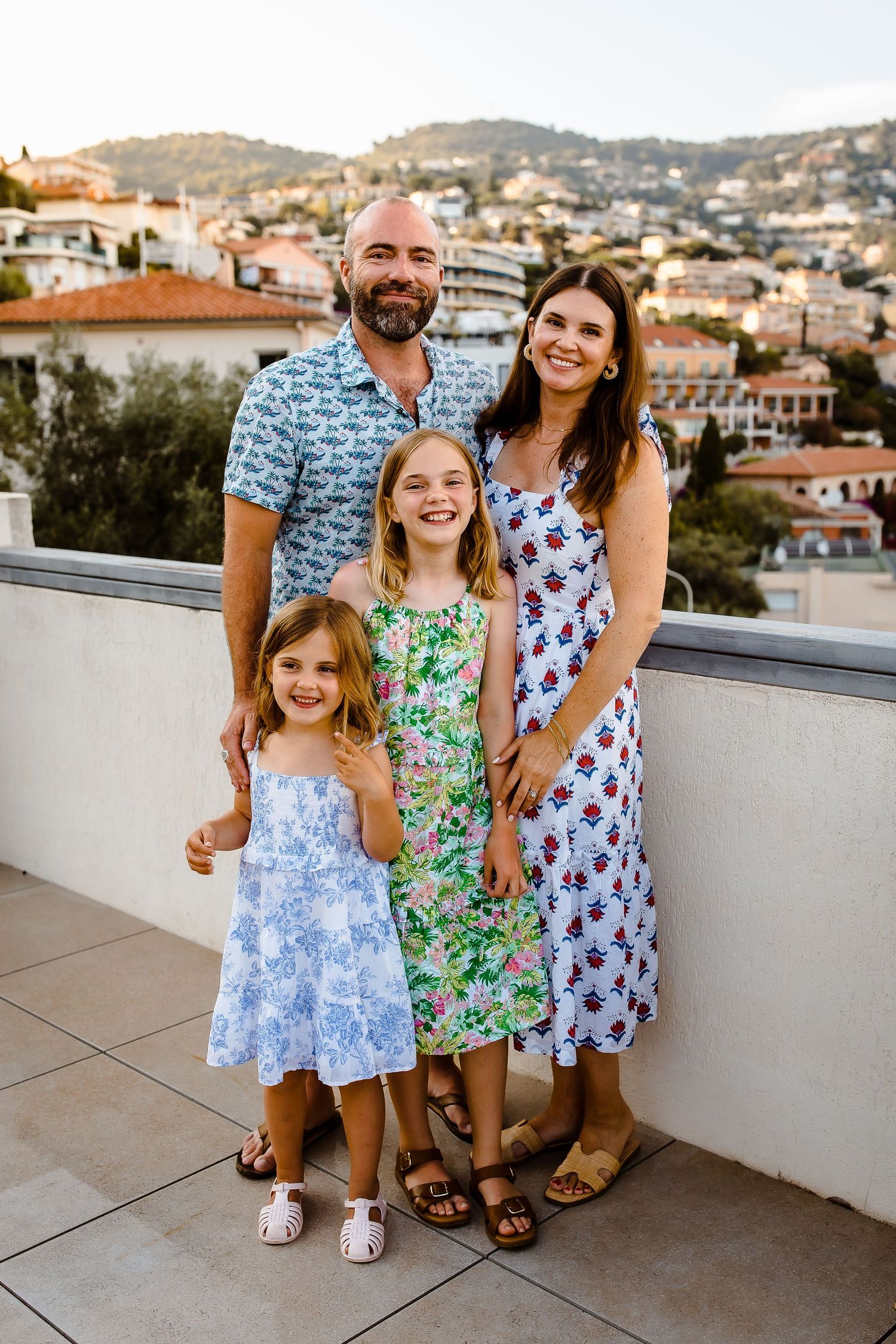 Family of four smiling on a European rooftop