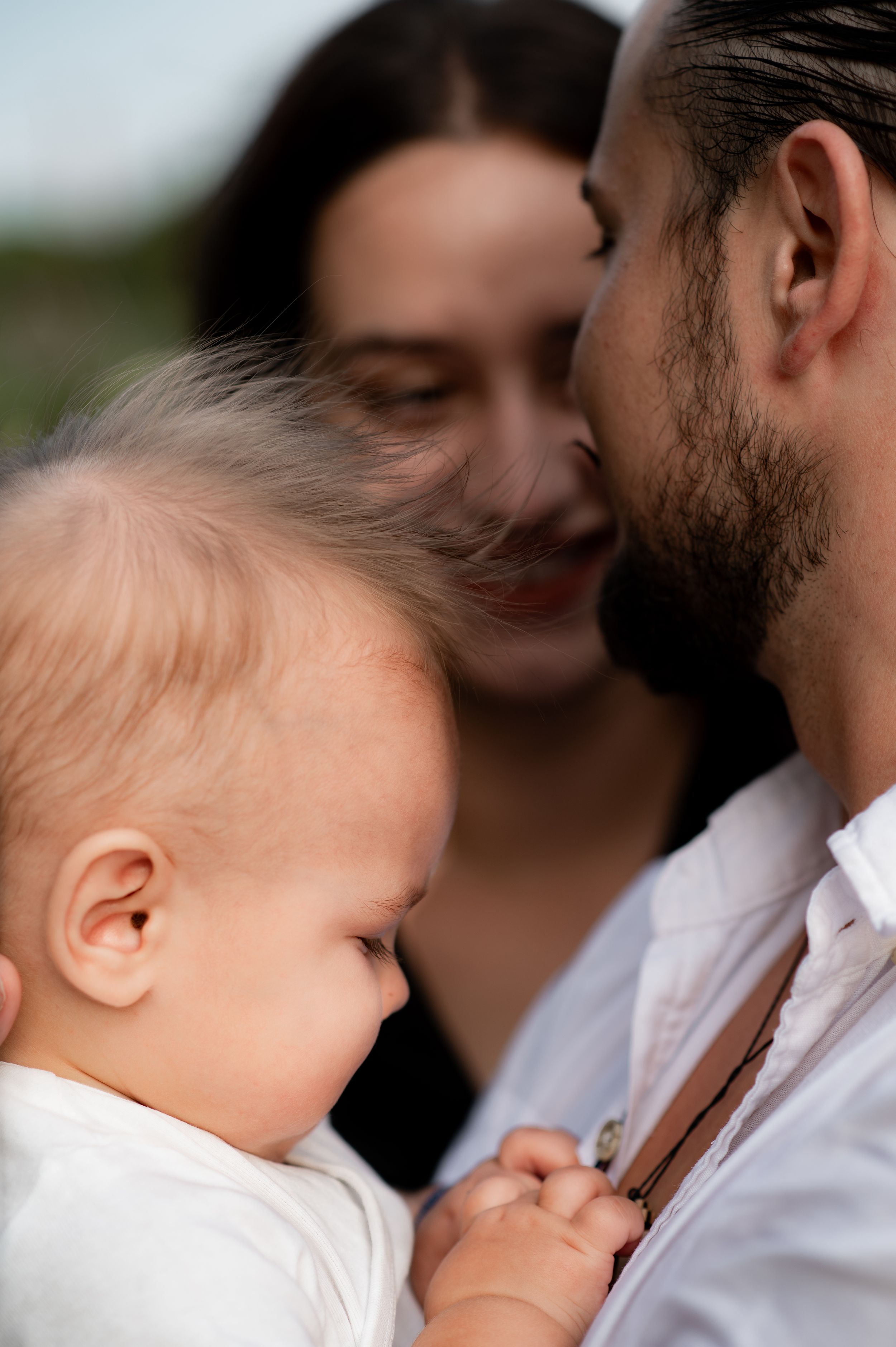 young family hugging with their baby boy in front of the camera