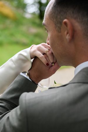 groom holding and kissing his brides hand with love after having their wedding ceremony in Ireland
