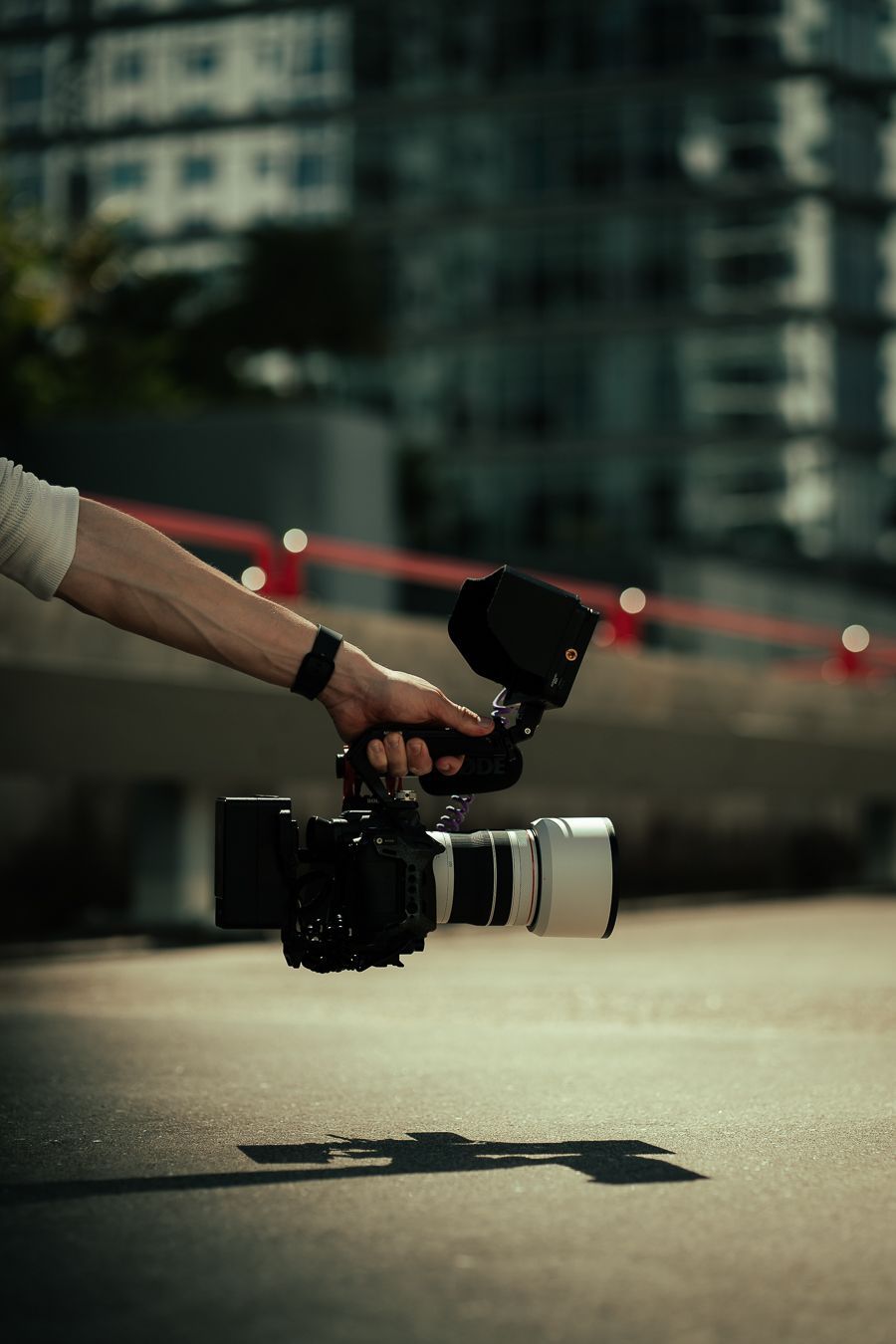 Behind the scenes shot of Mannyportraits filming in Miami with Canon camera and cinematic lens setup.