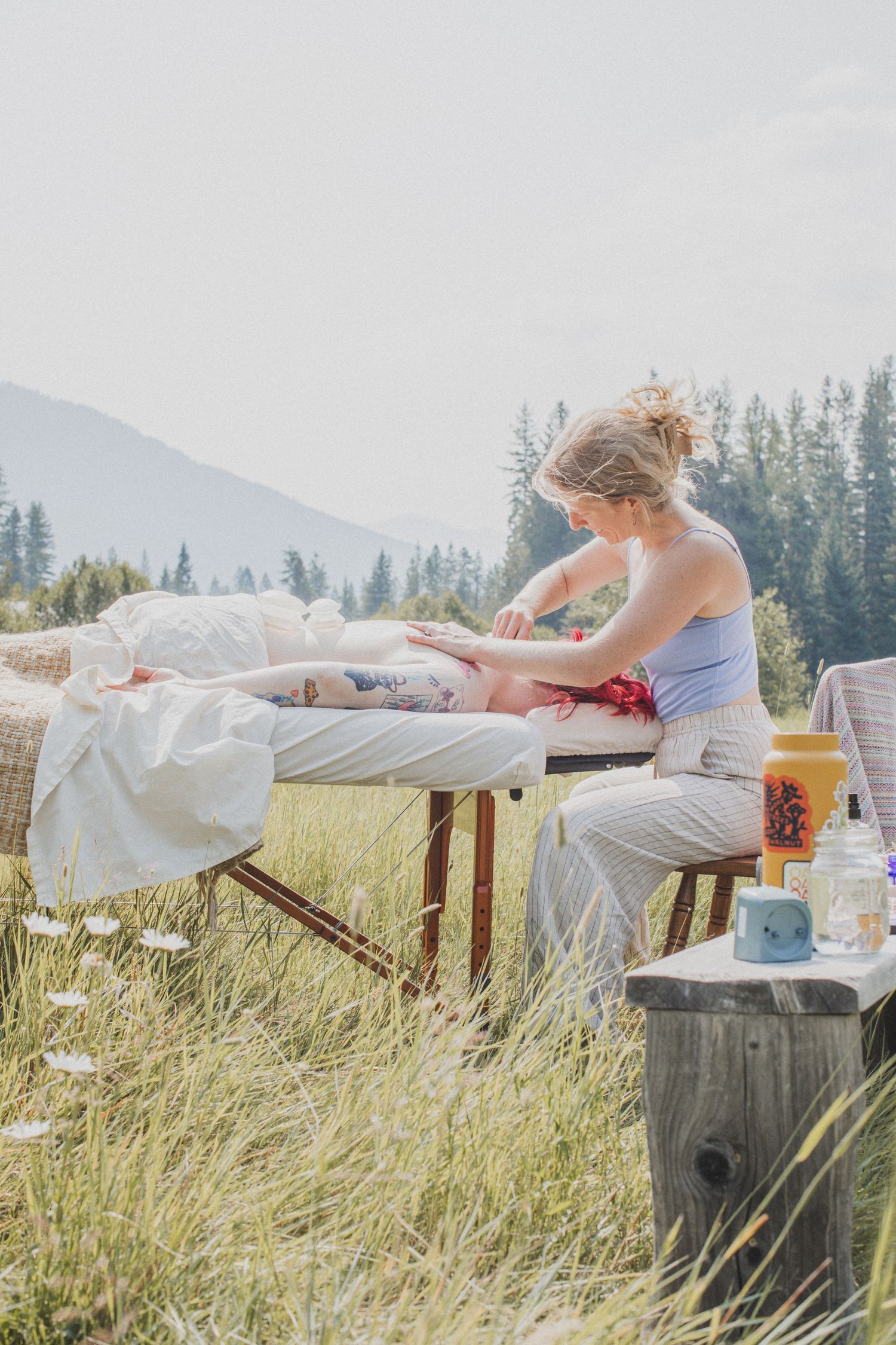 An outdoor massage table setup in a mountain meadow of Montana during a wellness retreat.