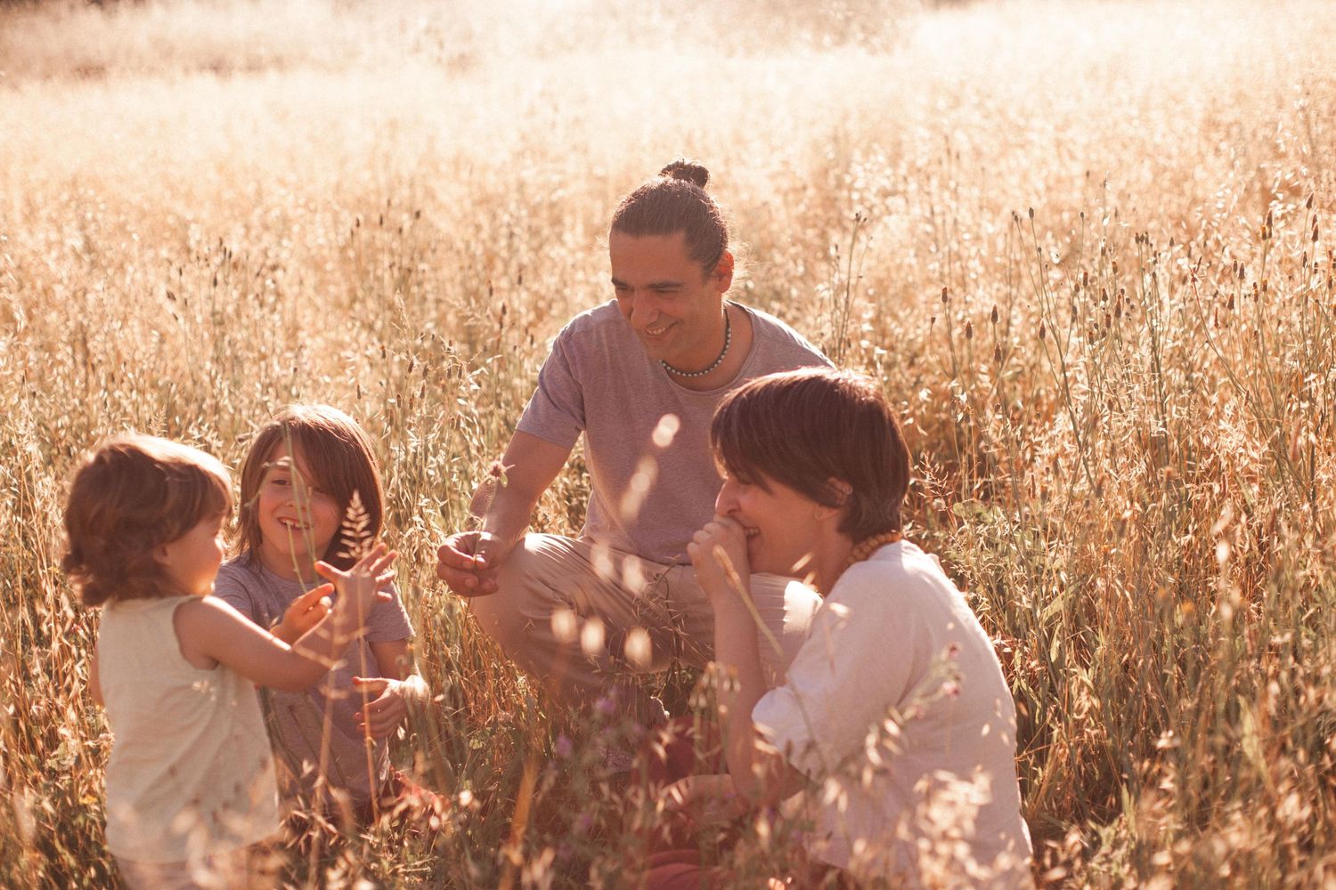 famiglia in campo di spighe in estate, sessione fotografica famiglia a Peschiera Borromeo al tramonto con mamma papà due fratelli