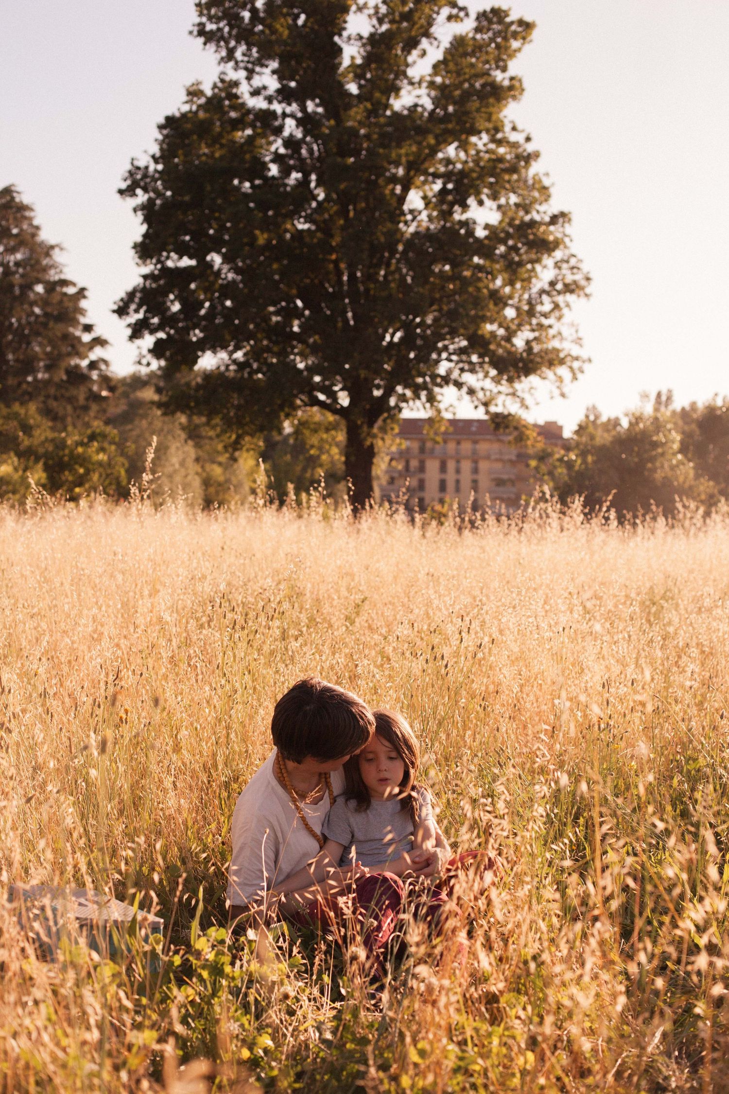 mamma con figlio in campo di spighe in estate, sessione fotografica famiglia a Peschiera Borromeo al tramonto con mamma papà due fratelli