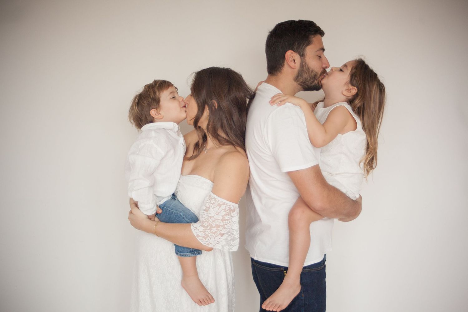 sessione Maternity in famigli a Milano, a Peschiera Borromeo, in Provincia di Milano, vestiti di bianchi, baci e divertimento in famiglia.