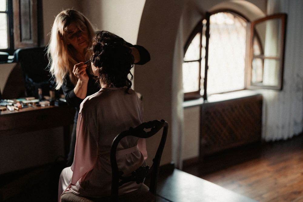 A backlit interior scene shows a silhouette at a desk in front of an arched window with moody natural lighting.