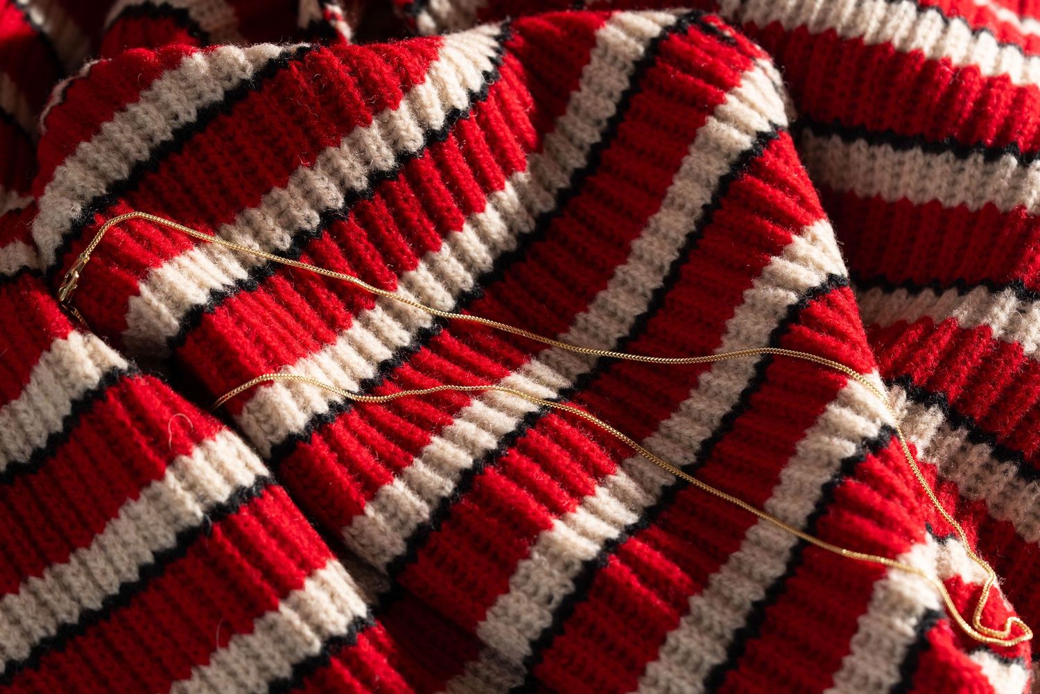 Red and white striped knitted fabric texture with diagonal lines creates a festive candy cane pattern.
