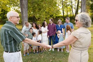 A sequence of outdoor photos showing people greeting and mingling at a casual daytime gathering in a park setting.