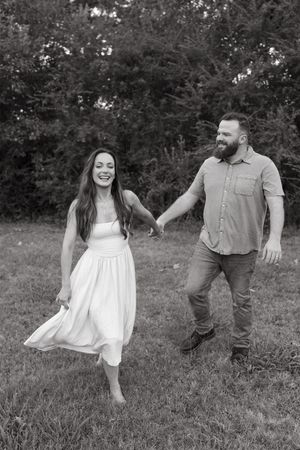 Black and white sequence of a couple playfully dancing in a grassy field.