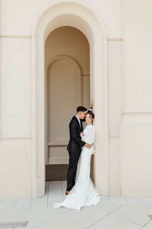 A romantic wedding couple shares intimate moments under elegant white archways in a series of connected photos.