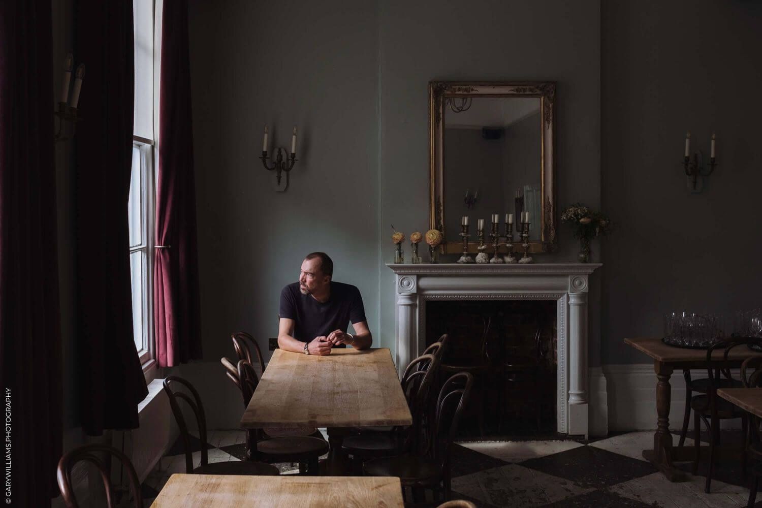 Dimly lit interior of an empty vintage restaurant with dark walls and classic decor.
