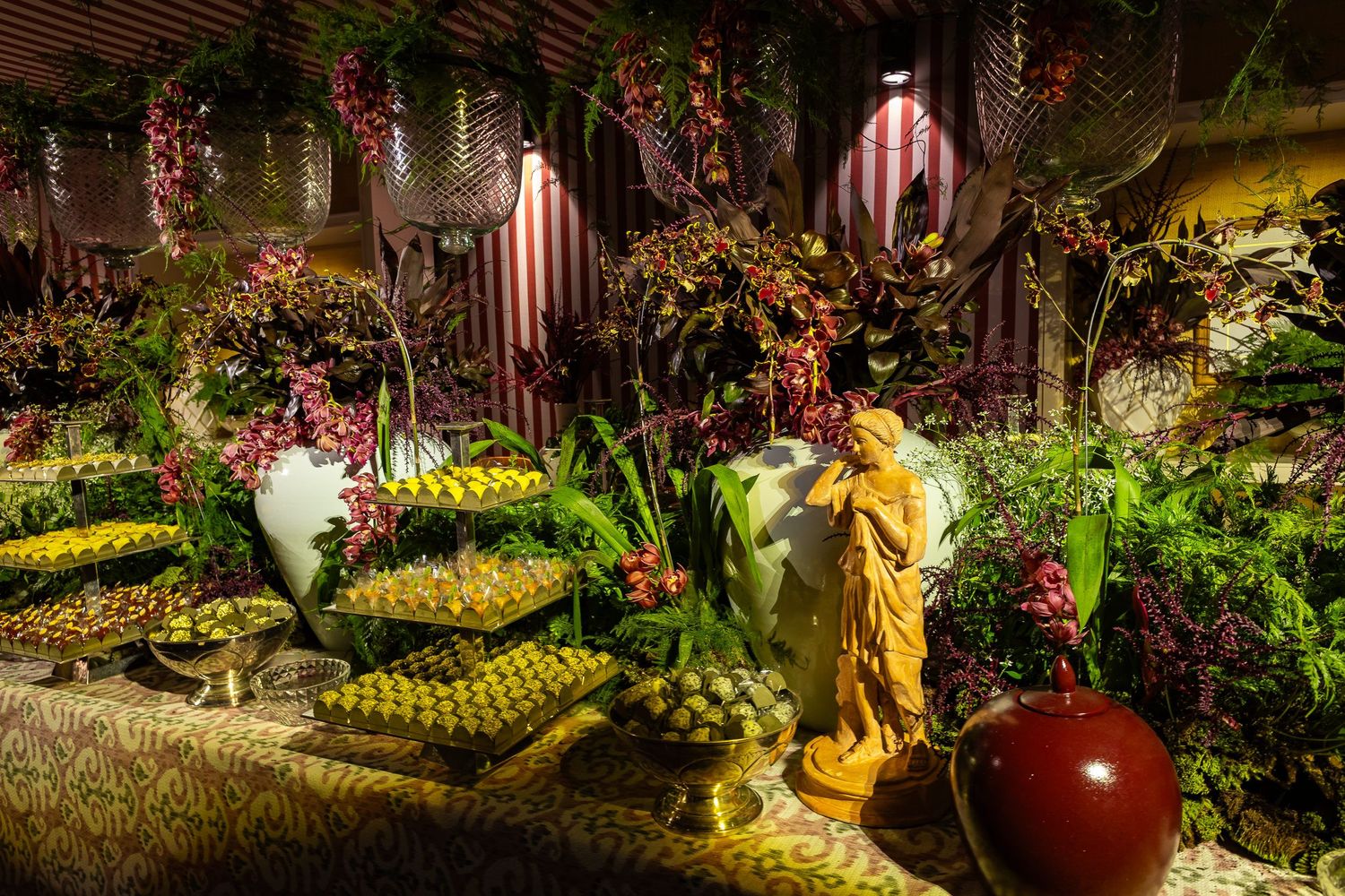 Colorful garden display with fresh produce, pumpkins, and autumn flowers arranged in rustic outdoor market setting.