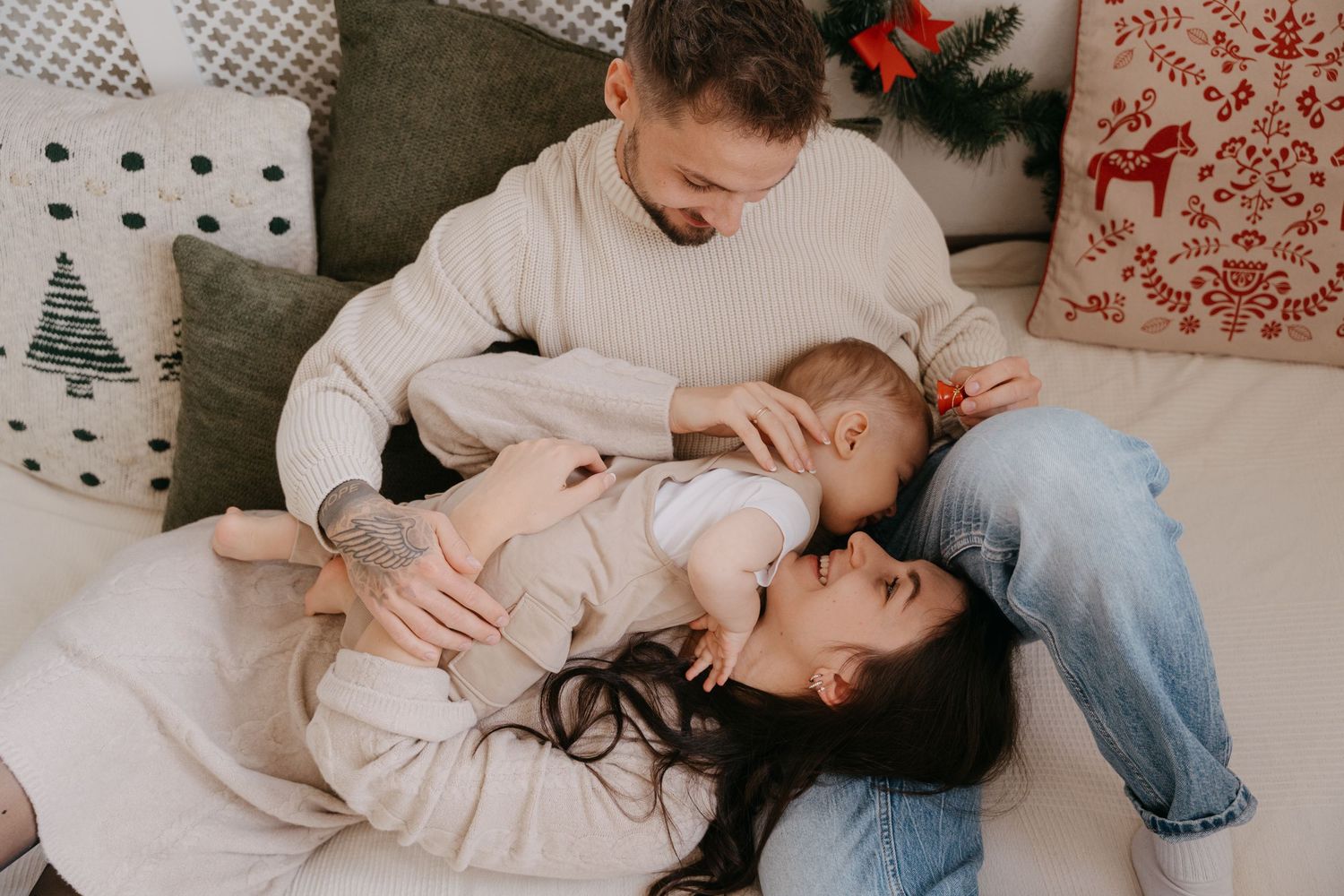 A cozy family moment on the couch with holiday decorations visible in the background.