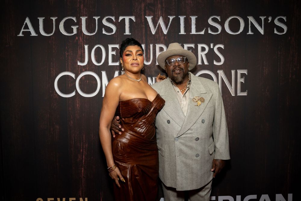 Two guests pose at August Wilson's Joe Turner's Come and Gone Broadway premiere event backdrop.
