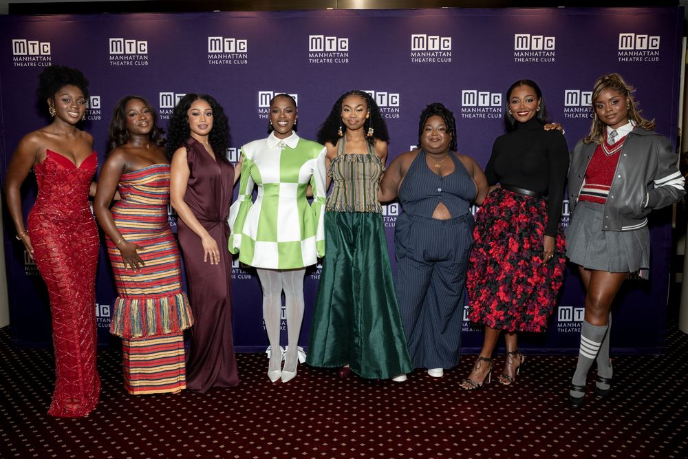 Group of eight women posing together at an MTC event, wearing elegant and colorful outfits at a formal gathering.
