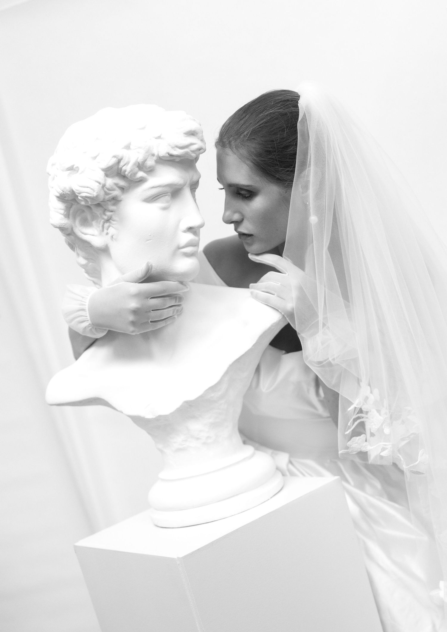Artistic black and white portrait series featuring a classical statue and bridal veil.