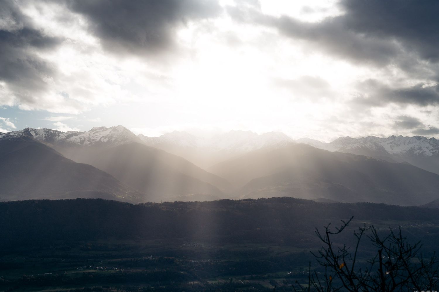 vue sur le massif de belledonne avec percées de lumière entre les nuages depuis le rocher de manettaz