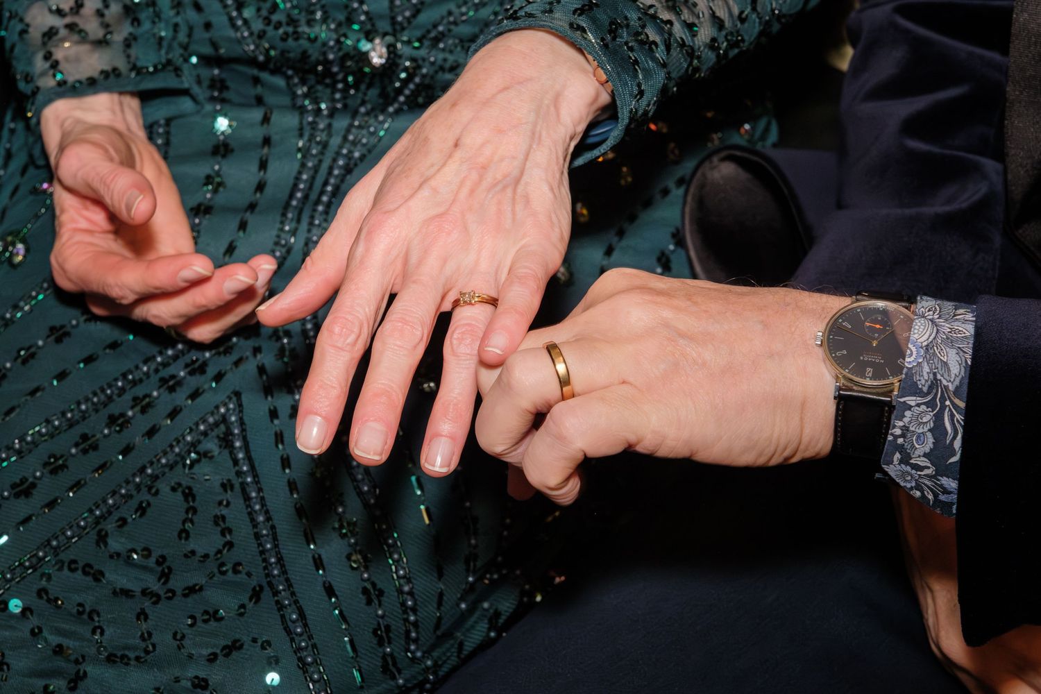 Close-up sequence showing hands performing sleight of hand magic trick with a coin on dark background.