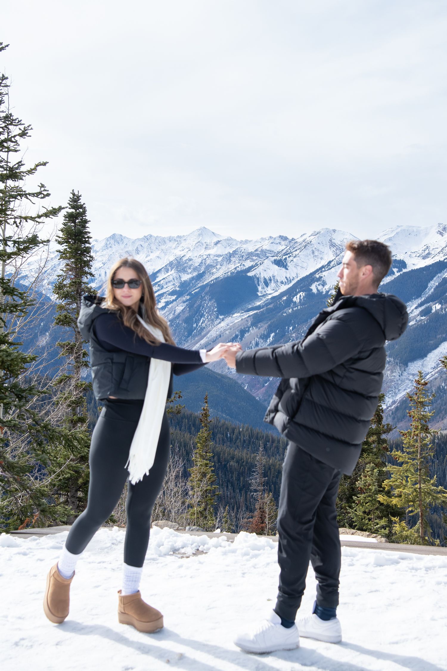 Playful and candid engagement photos in the snow at The Aspen Wedding Deck.