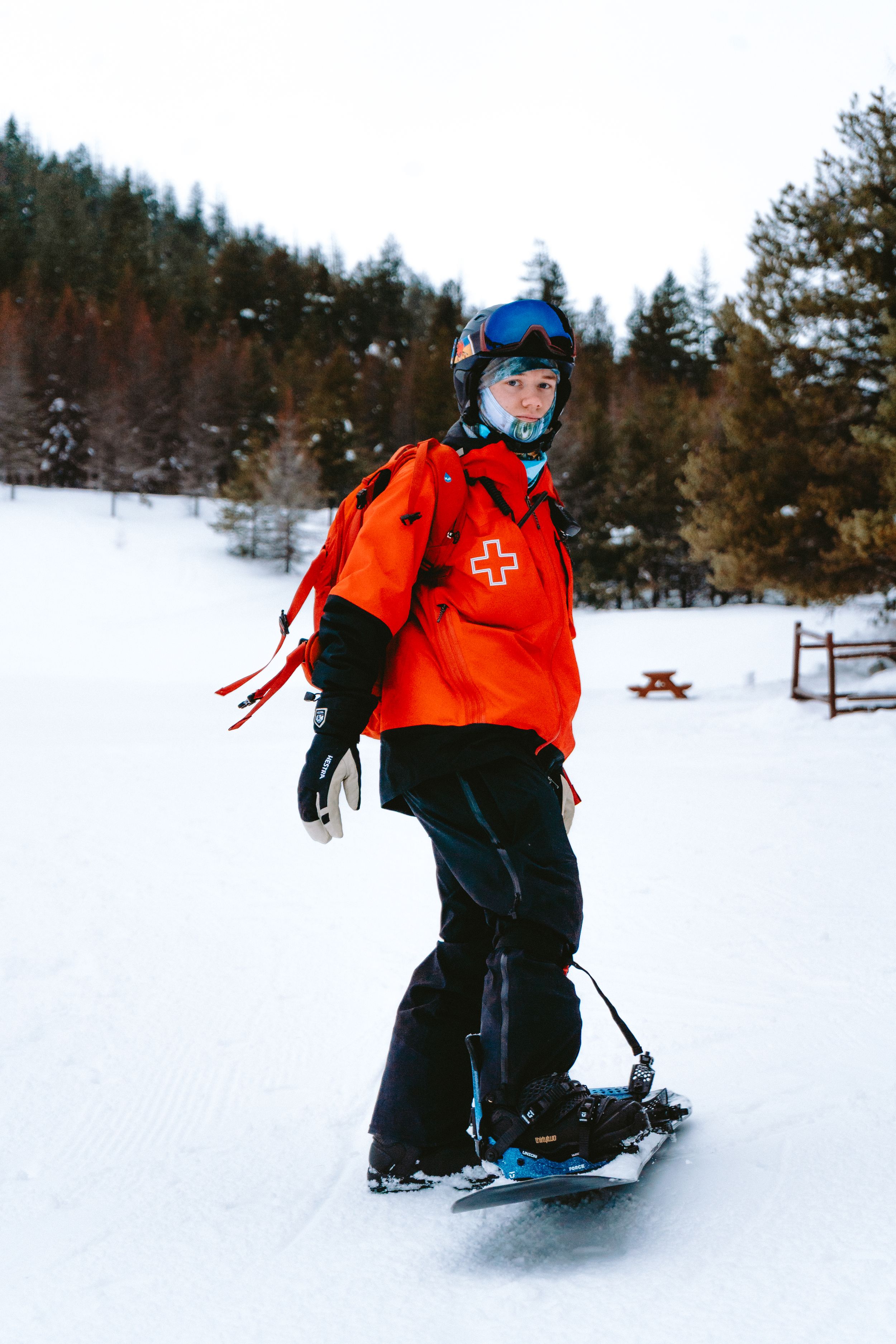 Skiers in bright orange jackets gliding across a snowy winter landscape.