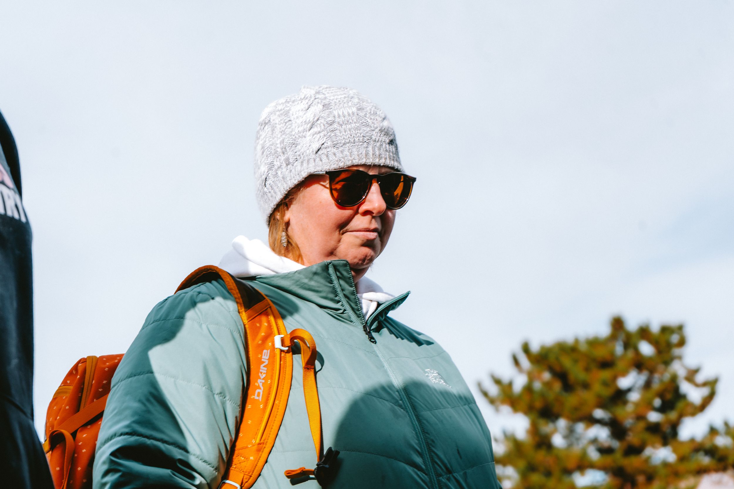 Person in winter gear walking through mountain scenery.