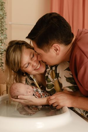 couple heureux pendant une séance photo thalasso bain bébé dans les yvelines