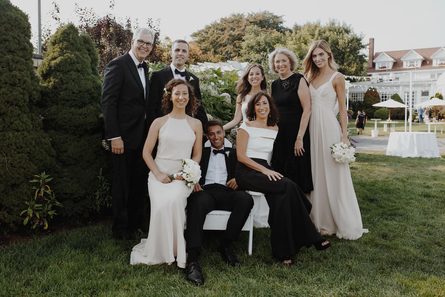Wedding party walks through a scenic field at sunset creating silhouettes against the horizon.